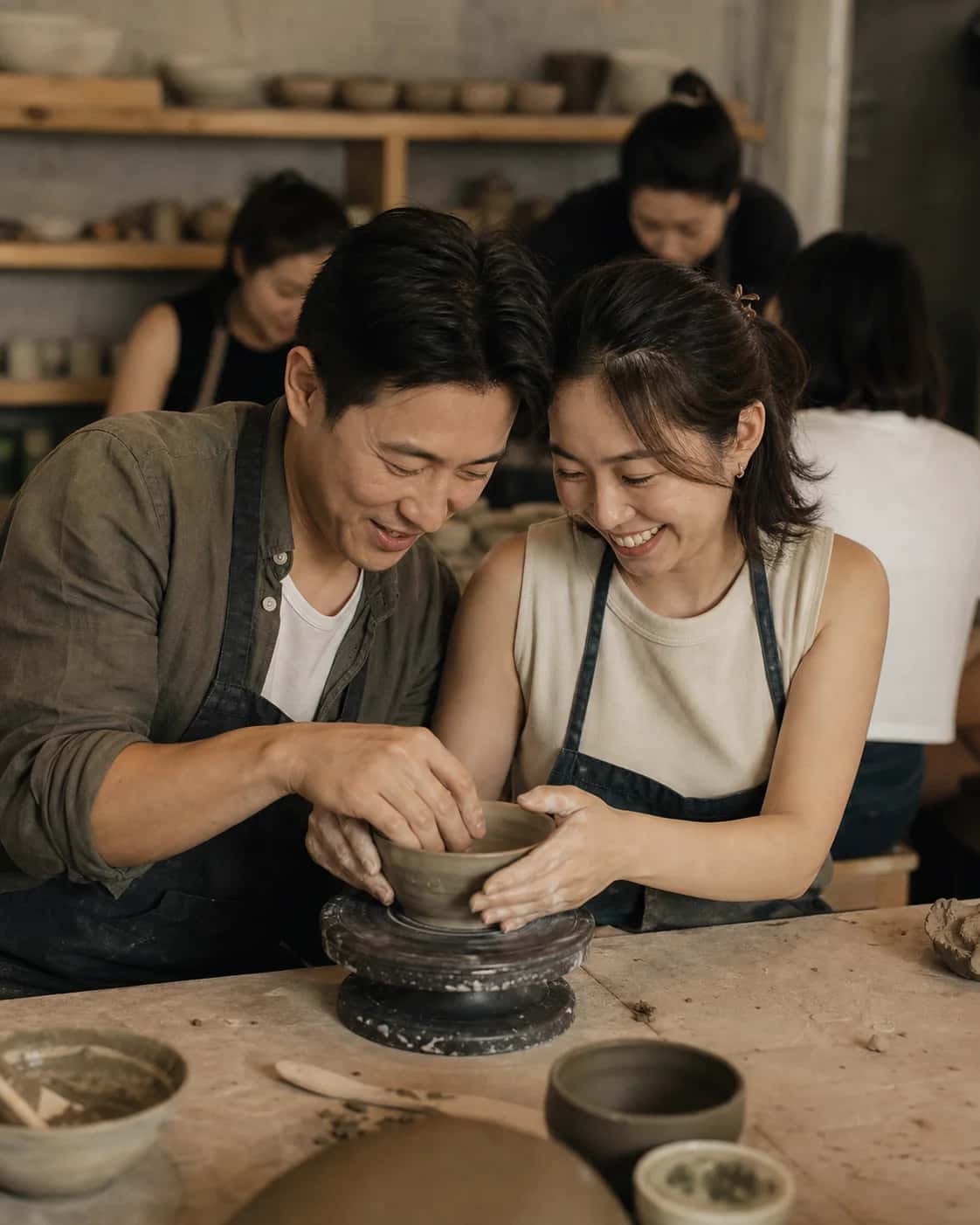 Two adults make pottery together in a Hong Kong studio; an illustrative campaign scene, not a photo of Another Half members.