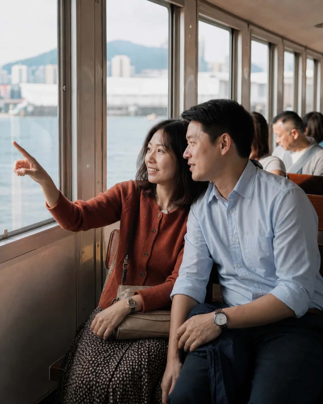 Illustrative brand scene of two adults looking towards the harbour from a ferry; not a member photo or testimonial.